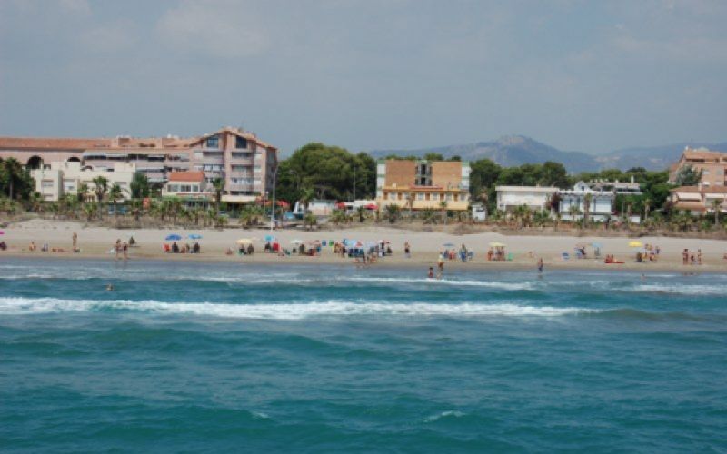 Vista de la playa con montañas al fondo